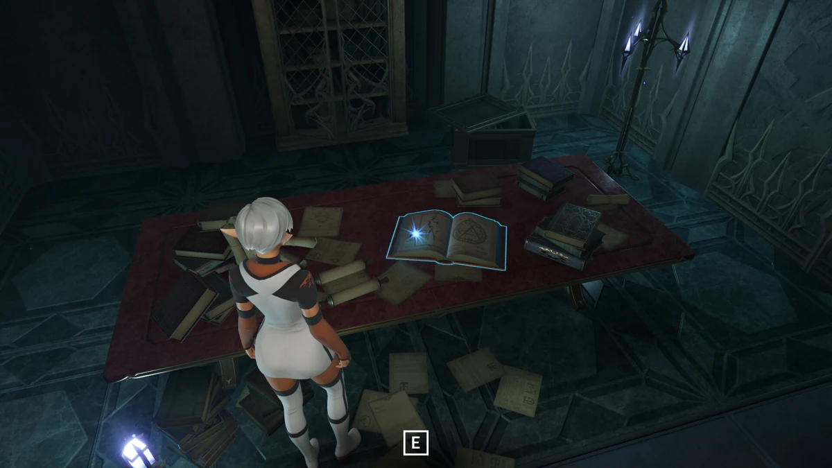 Il giocatore esamina dei libri sparsi su una scrivania in uno studio in pietra.